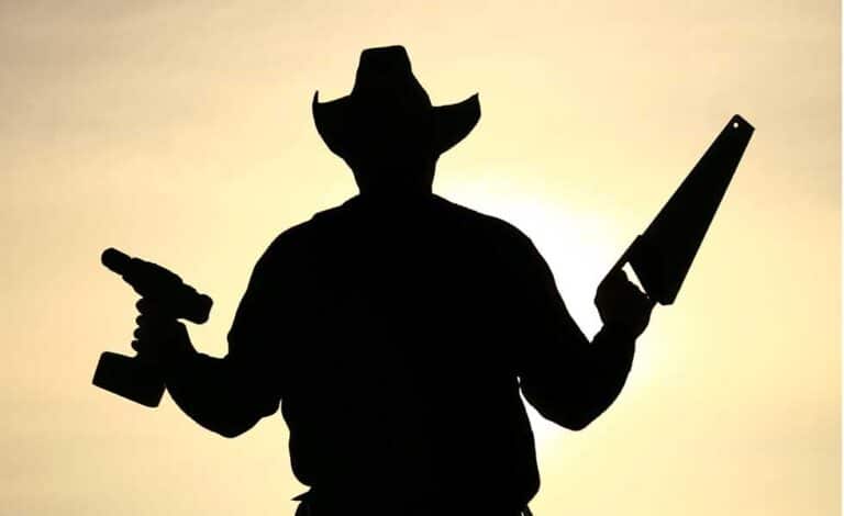 Silhouette of a man wearing a had and holding a saw and drill